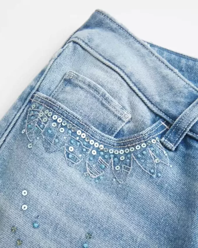 Jeans a zampa con paillettes lavaggio chiaro e vita ultra bassa effetto consumato