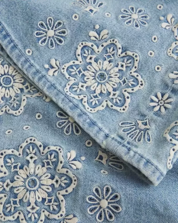 Jeans a zampa con ricamo floreale e lavaggio chiaro a vita bassissima