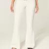 Jeans a zampa con tasche ricamate bianche a vita bassissima