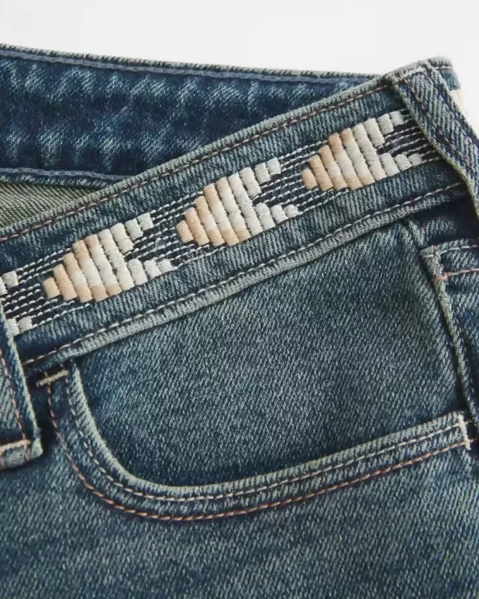 Jeans a zampa ricamati a lavaggio medio e vita bassissima