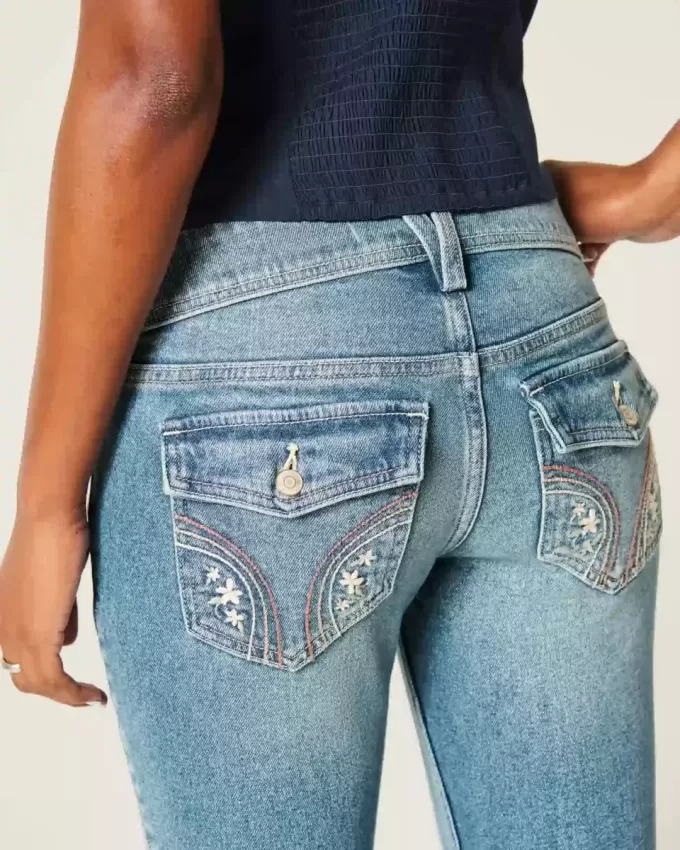 Jeans bootcut a vita bassa con lavaggio medio e motivi floreali ricamati