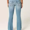 Jeans bootcut a vita bassa con lavaggio medio e motivi floreali ricamati