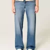 Jeans larghi a vita bassa con cuori borchiati e lavaggio medio