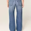 Jeans larghi a vita bassa con cuori borchiati e lavaggio medio