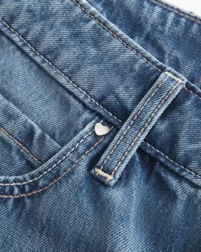 Jeans larghi a vita bassa con cuori borchiati e lavaggio medio