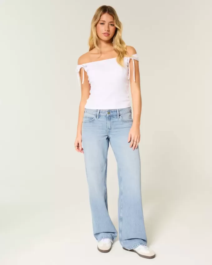 Jeans larghi a vita bassa con fiocchi borchiati e lavaggio chiaro