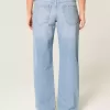 Jeans larghi a vita bassa con fiocchi borchiati e lavaggio chiaro