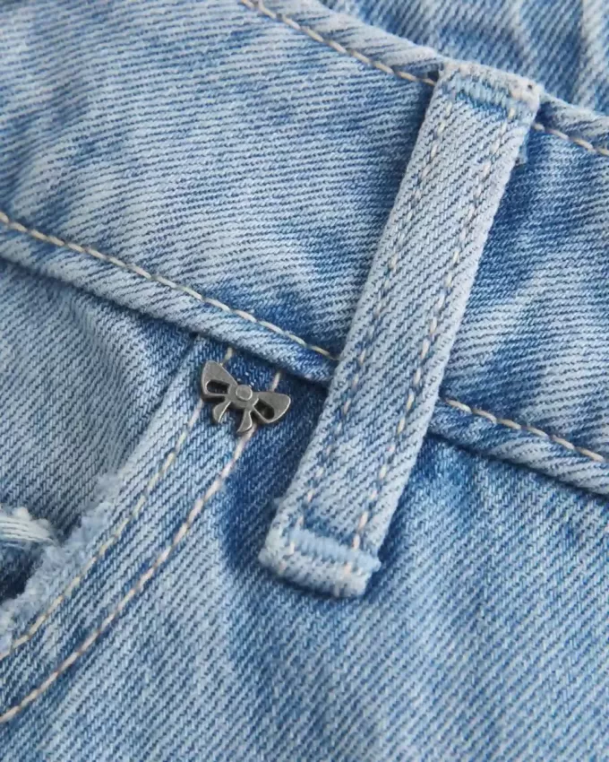 Jeans larghi a vita bassa con fiocchi borchiati e lavaggio chiaro