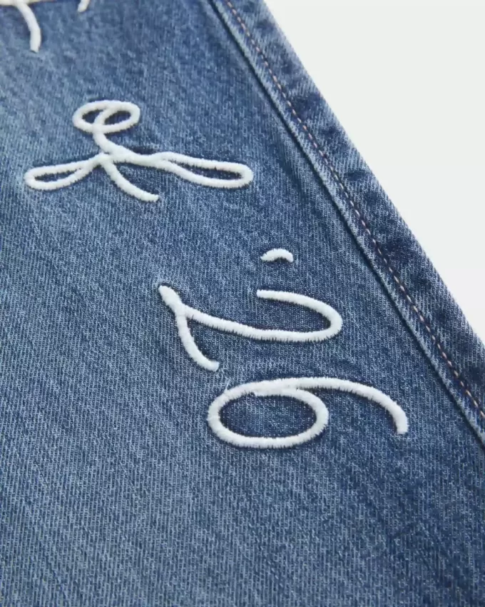 Jeans larghi a vita bassa e lavaggio scuro, modello Class of ’26, ricamati