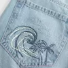 Jeans larghi con stampa grafica e lavaggio chiaro strappati a vita bassa