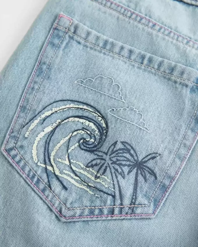 Jeans larghi con stampa grafica e lavaggio chiaro strappati a vita bassa