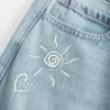 Jeans larghi con stampa grafica e lavaggio chiaro strappati a vita bassa