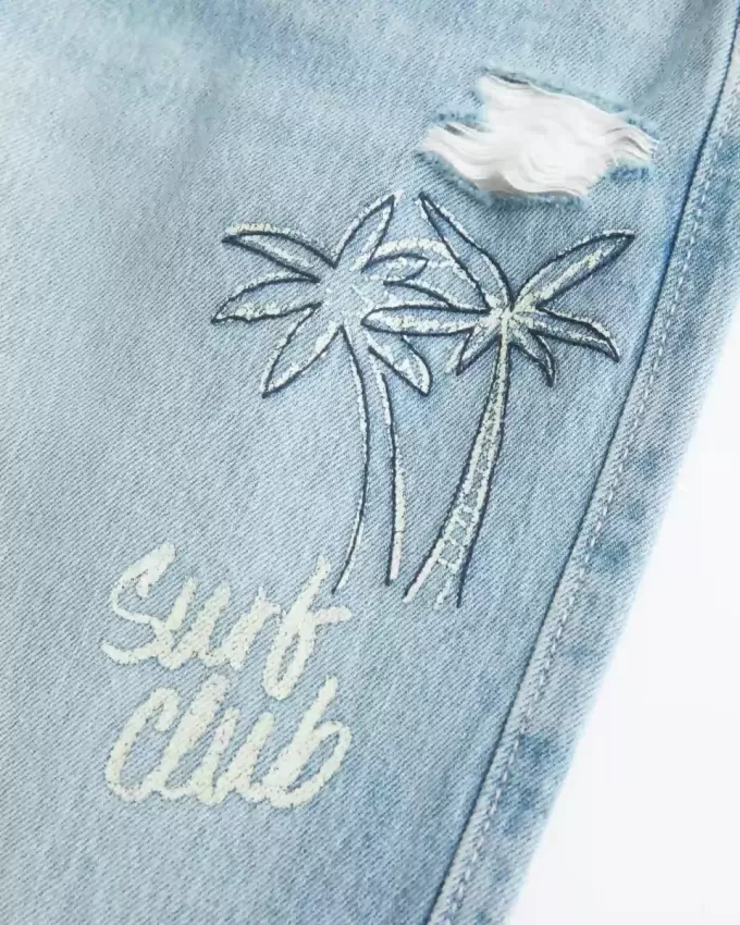 Jeans larghi con stampa grafica e lavaggio chiaro strappati a vita bassa
