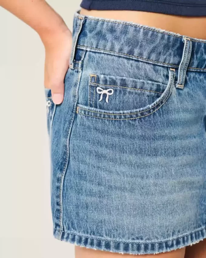 Mini gonna-pantalone in denim a vita bassa con fiocco ricamato