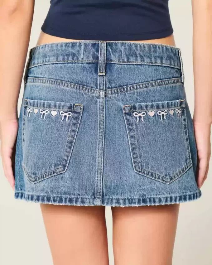 Mini gonna-pantalone in denim a vita bassa con fiocco ricamato