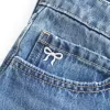 Mini gonna-pantalone in denim a vita bassa con fiocco ricamato