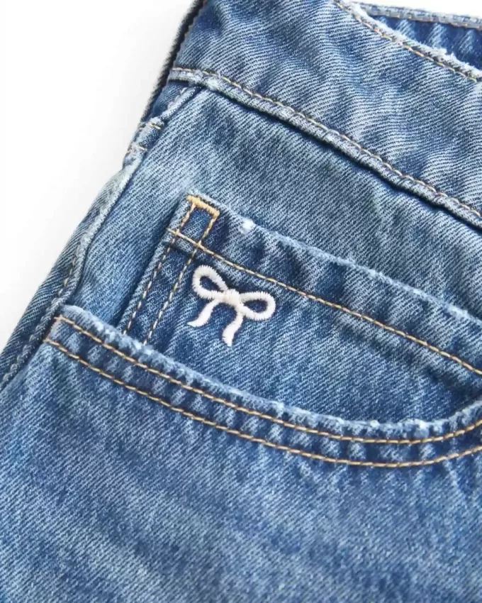 Mini gonna-pantalone in denim a vita bassa con fiocco ricamato