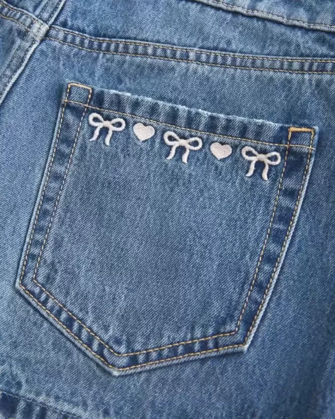 Mini gonna-pantalone in denim a vita bassa con fiocco ricamato