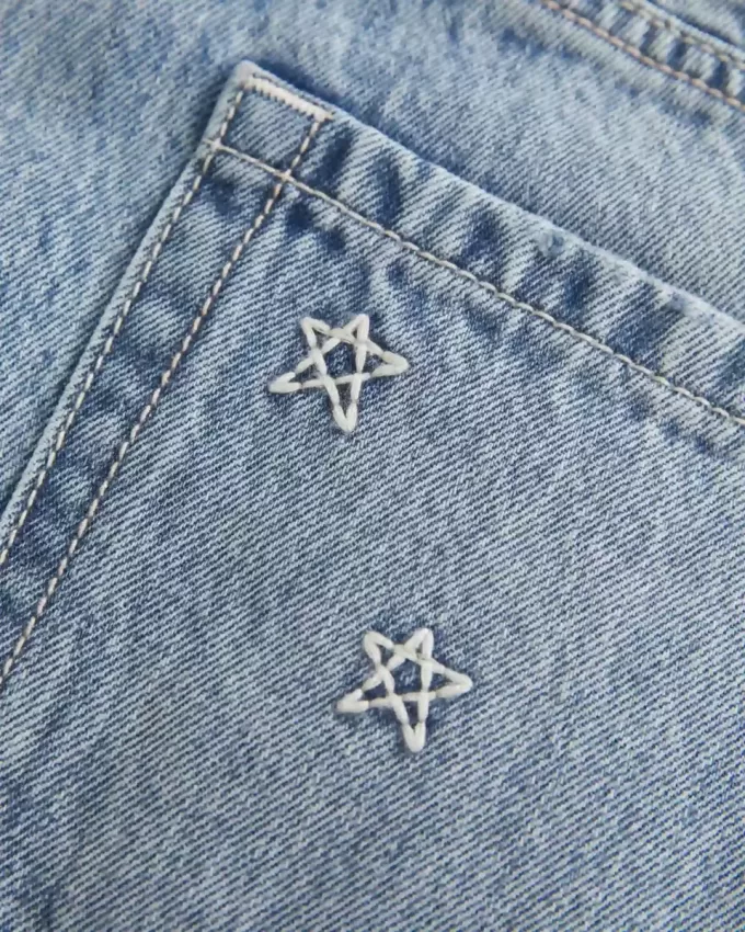 Mini gonna-pantalone in denim a vita bassa con stelle ricamate