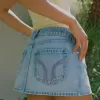 Mini gonna-pantalone in denim chiaro ricamato rosa a vita bassa