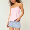 Mini gonna-pantalone in denim chiaro ricamato rosa a vita bassa