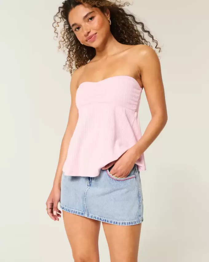 Mini gonna-pantalone in denim chiaro ricamato rosa a vita bassa