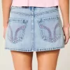 Mini gonna-pantalone in denim chiaro ricamato rosa a vita bassa