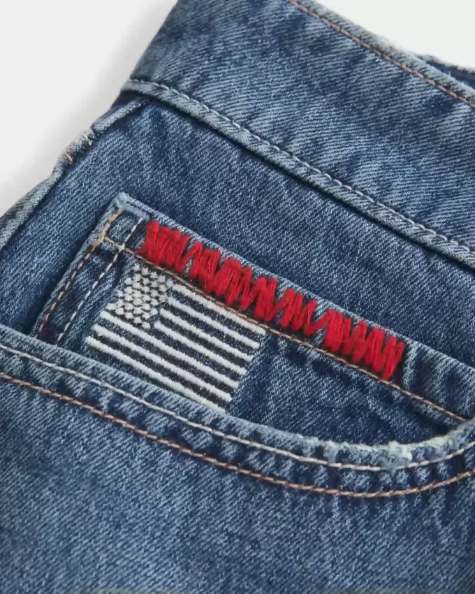 Mini gonna-pantalone in denim con bandiera ricamata e lavaggio medio a vita bassa