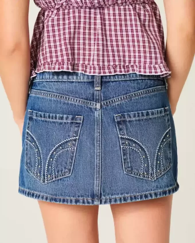 Mini gonna-pantalone in denim con borchie a vita bassa