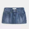 Mini gonna-pantalone in denim con borchie a vita bassa