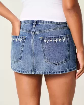Mini gonna-pantalone in denim con fiocco ricamato a vita bassa e sinuosa