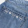 Mini gonna-pantalone in denim con fiocco ricamato a vita bassa e sinuosa