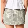 Mini gonna-pantalone in denim mimetico a vita bassa e sinuosa